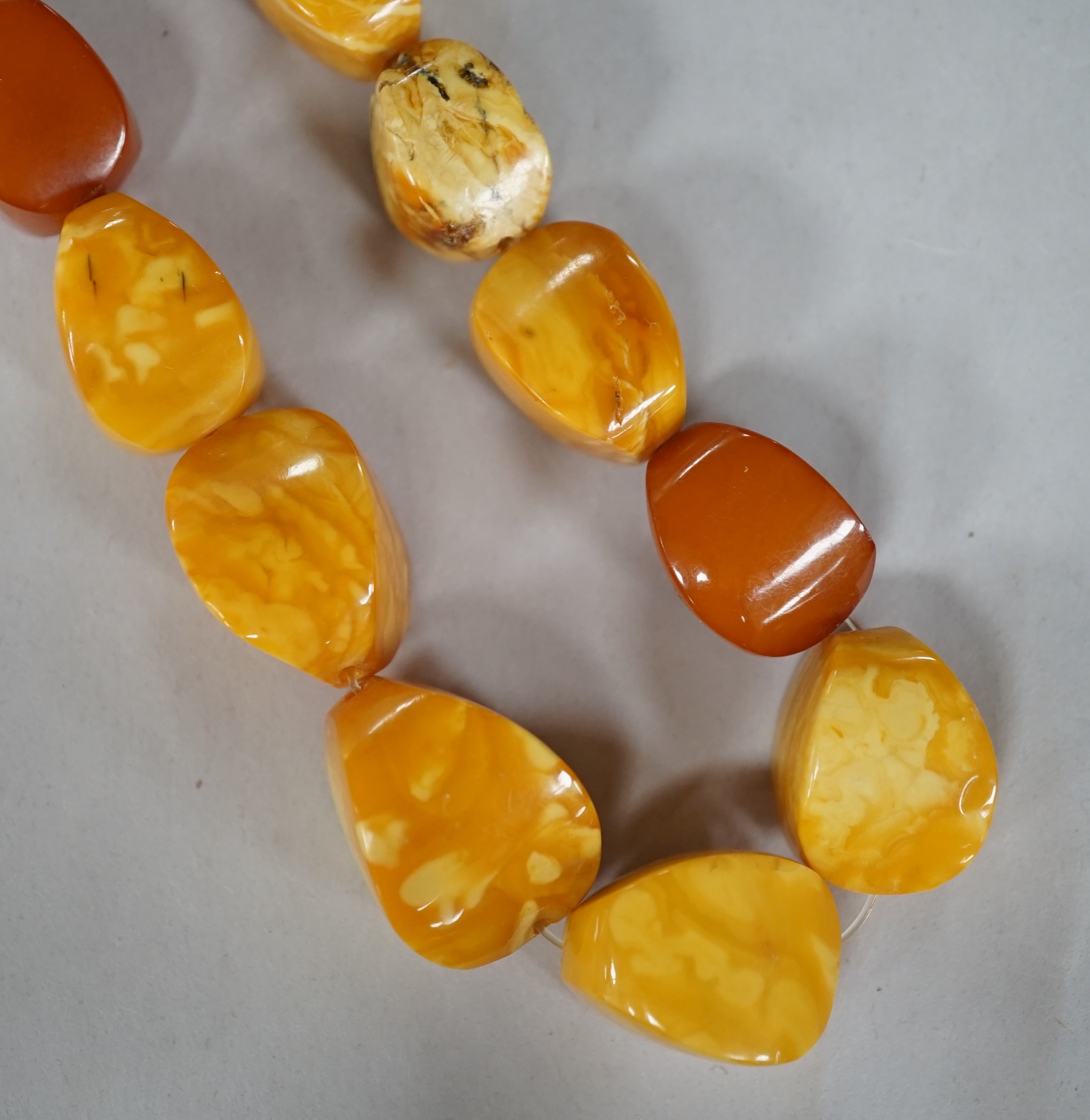 A single strand amber pebble bead necklace, 78cm, gross weight 93 grams. Condition - poor to fair